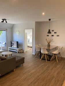 a living room with a table and chairs and a couch at Bauernhof-Steffens in Tating
