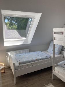 a bedroom with a white bed and a window at Bauernhof-Steffens in Tating