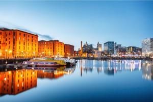 a city skyline with boats in the water at night at Cosy Anfield Home in Liverpool