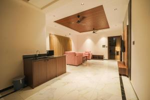 a large living room with pink chairs and a ceiling at Casa Marina Beachfront Resort in Padubidri