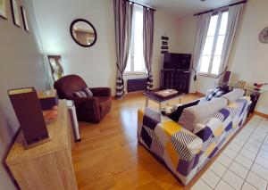 a living room with a couch and a chair at La Petite Forge - Quai 75 & Quai 80 in Châtellerault