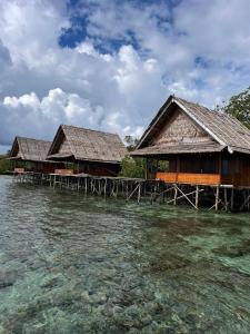 two houses on the water near the ocean at Raja Ampat Holidays in Besir