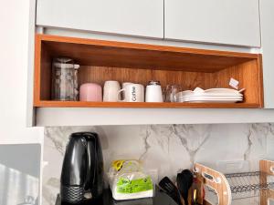 a cupboard with cups and other kitchen items in it at Casa Stays in Kiambu