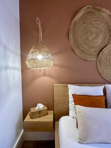 a bedroom with a bed and a chandelier at Studio 2 des Remparts à 5mins de Charleville-Mézières in Warcq