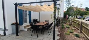 a table and chairs under an umbrella on a patio at Ferienhaus beim Boten in Neuburg an der Kammel