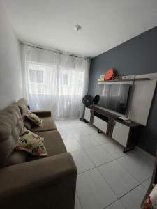 a living room with a couch and a flat screen tv at Przibilwiez Hause in João Pessoa