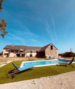 a house with a swimming pool in front of a house at Auberge des Riders in Loze