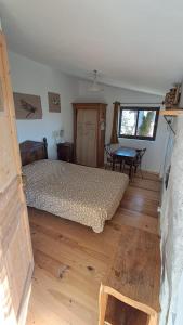a bedroom with a bed and a table and a window at Chambre de la roche trouee GR49 in Trigance +10 photos