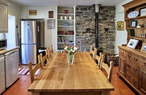 a kitchen with a wooden table with a vase of flowers at Glenalbyn Cottage in Saint Fillans