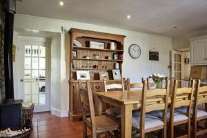 a dining room with a table and a clock on the wall at Glenalbyn Cottage in Saint Fillans