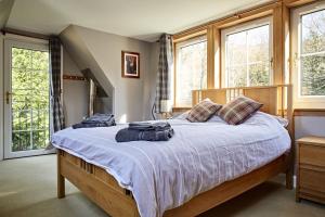 a bedroom with a large bed with blue towels on it at Glenalbyn Cottage in Saint Fillans