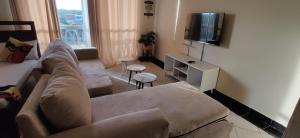 a living room with a couch and a tv at Shanzu Studio Stamford Apartment in Mombasa +11 photos