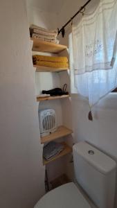 a small bathroom with a toilet and a window at Chambre de la roche trouee GR49 in Trigance