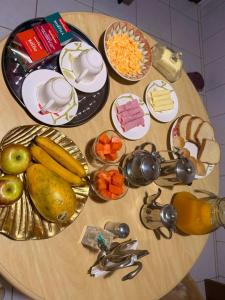 a wooden table topped with plates of food and fruit at Casa privada no Centro in São Gabriel +5 photos