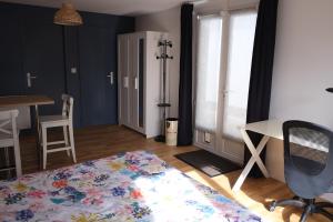 a room with a bed and a desk and a table at Beau studio calme, indépendant avec terrasse in Pessac