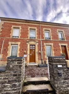 a brick building with a brown door on it at Studio 2 des Remparts à 5mins de Charleville-Mézières in Warcq