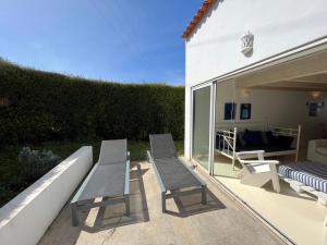 two chairs and a bench on a patio at Aljezur Houses 3 bedrooms 2 bathrooms with Condo Pool in Aljezur