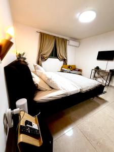a bedroom with a bed and a desk with a telephone at אמדר בעתיקה in Beer Sheva