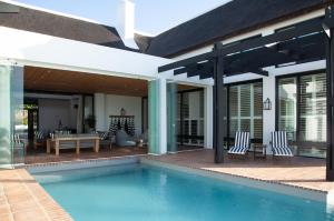 a house with a swimming pool and a patio at Manor at Longridge in Helderberg