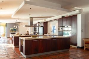 a large kitchen with wooden cabinets and a kitchen island at Manor at Longridge in Helderberg