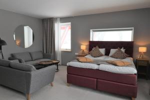 a bedroom with a bed and a couch and a mirror at Hotell Klövsjöfjäll in Klövsjö +47 photos