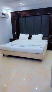 a bedroom with a large bed with a wooden headboard at فندق جولدن نيو روز بلازا جازان in Jazan