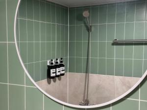 ein Badezimmer mit Dusche mit rundem Spiegel in der Unterkunft 부일파크 in Suwon