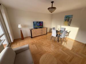 a living room with a table and chairs and a television at Apartament Elizabeth in Gdynia