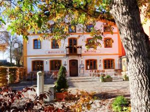 an orange and white building with a tree at Huberwirt am Kellerberg in Wasserburg am Inn