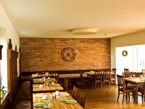 a restaurant with wooden tables and chairs and a brick wall at Huberwirt am Kellerberg in Wasserburg am Inn