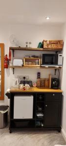 a kitchen with a counter top with a microwave and a counter top at The Snug in Haddenham