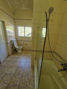 a bathroom with a tub and a toilet at Narmada Holiday Home in Ooty +92 photos