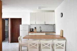 a kitchen with a wooden table and white cabinets at Apartment Stefani by El-Pi Tours in Njivice