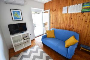 a living room with a blue couch and a tv at Apartment Stefani by El-Pi Tours in Njivice