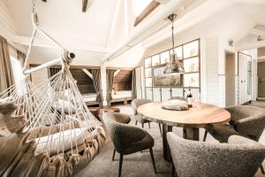 a room with a hammock and a table and chairs at Hotel the Farmhouse No 50 - kostenfreies Parken! - Cafe & Eventrooms in Osnabrück