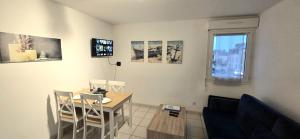 a dining room with a table and chairs and a window at Le Duplex t2 étoilé in Saint-Méloir-des-Ondes +17 photos