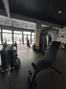 a gym with a chair and a television and people exercising at The Underground MOOTEL in Porumbacu de Jos