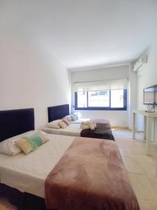 a room with three beds in a room at Osiris Plaza in Buenos Aires