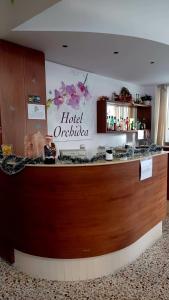a hotel reception counter with a hotel orilla sign on the wall at Hotel Orchidea Rimini in Rimini +21 photos