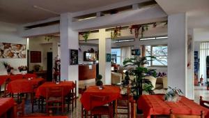 a dining room with red tables and chairs at Hotel Orchidea Rimini in Rimini