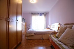 ein kleines Schlafzimmer mit einem Bett und einem Fenster in der Unterkunft Em Cima Da Areia in Póvoa de Varzim