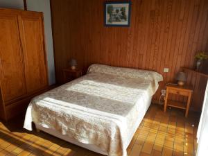 a small bedroom with a bed and two tables at Les Genêts Studio & Piscine in Eugénie-les-Bains