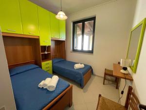 a room with two beds and a table and a window at Sweet Summer House in Campofelice di Roccella +40 photos