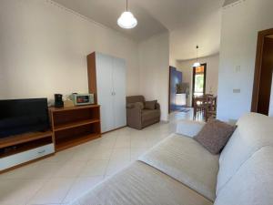 a living room with a bed and a flat screen tv at Sweet Summer House in Campofelice di Roccella