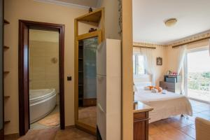 a bedroom with a tub and a bed and a bathroom at Aerino House in Dassia +50 photos