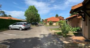 a car parked in the driveway of a house at Les Genêts Studio & Piscine in Eugénie-les-Bains