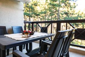a table with a bowl of fruit on a balcony at Апартамент Боров рай in Velingrad