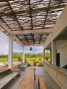 a pavilion with benches and a wooden ceiling at Wa'a House Batukaras in Batukaras