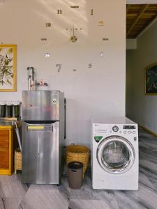 a kitchen with a washing machine and a washer at Wa'a House Batukaras in Batukaras