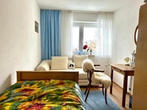 a bedroom with a bed and a desk and a window at Ferienwohnung Bärbel in Freyung